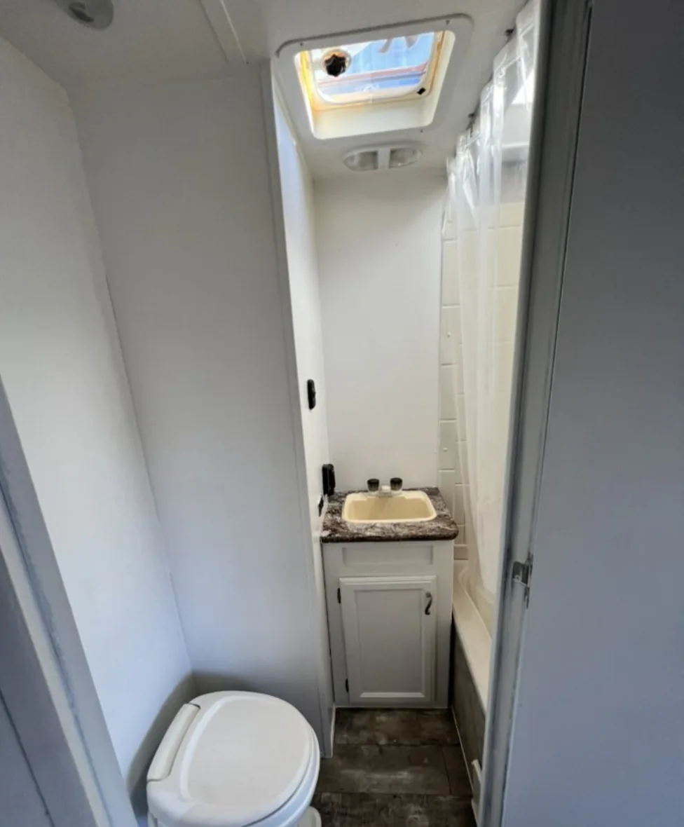 Finished RV bathroom with clean cabinetry, sink and shower