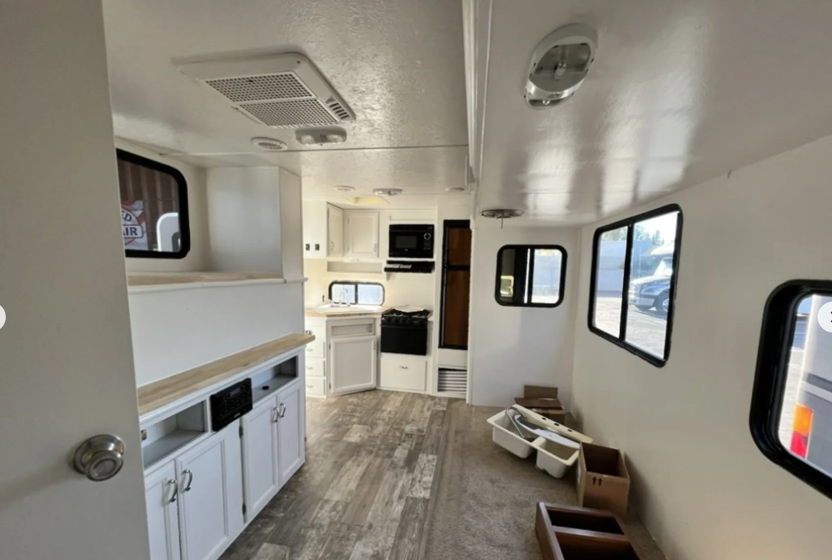 Bright repaired camper interior with renewed cabinetry and flooring